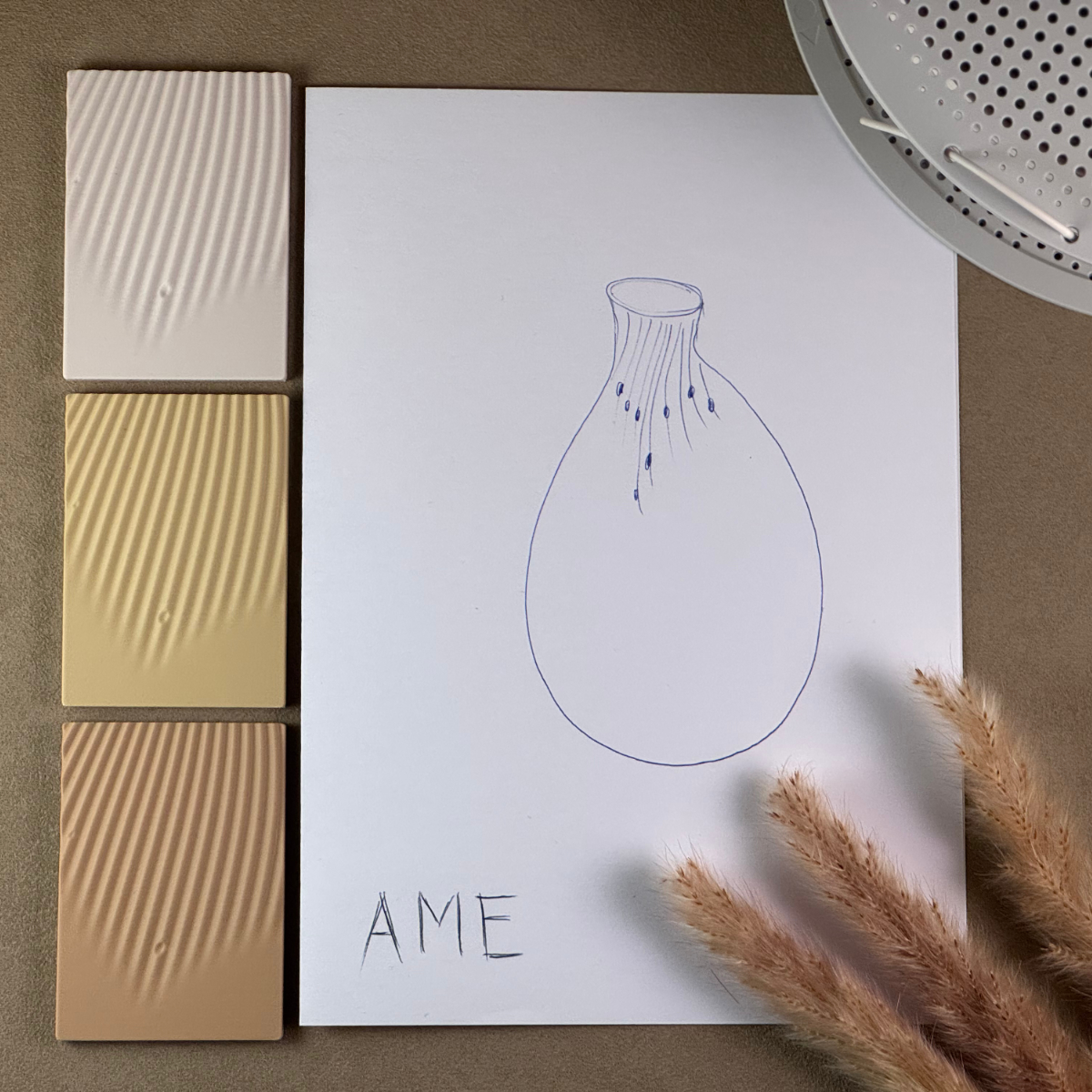 Skizze der Vase Ame auf Papier, daneben Farbmuster in Kinari, Suna und Asahi und Trockengräser